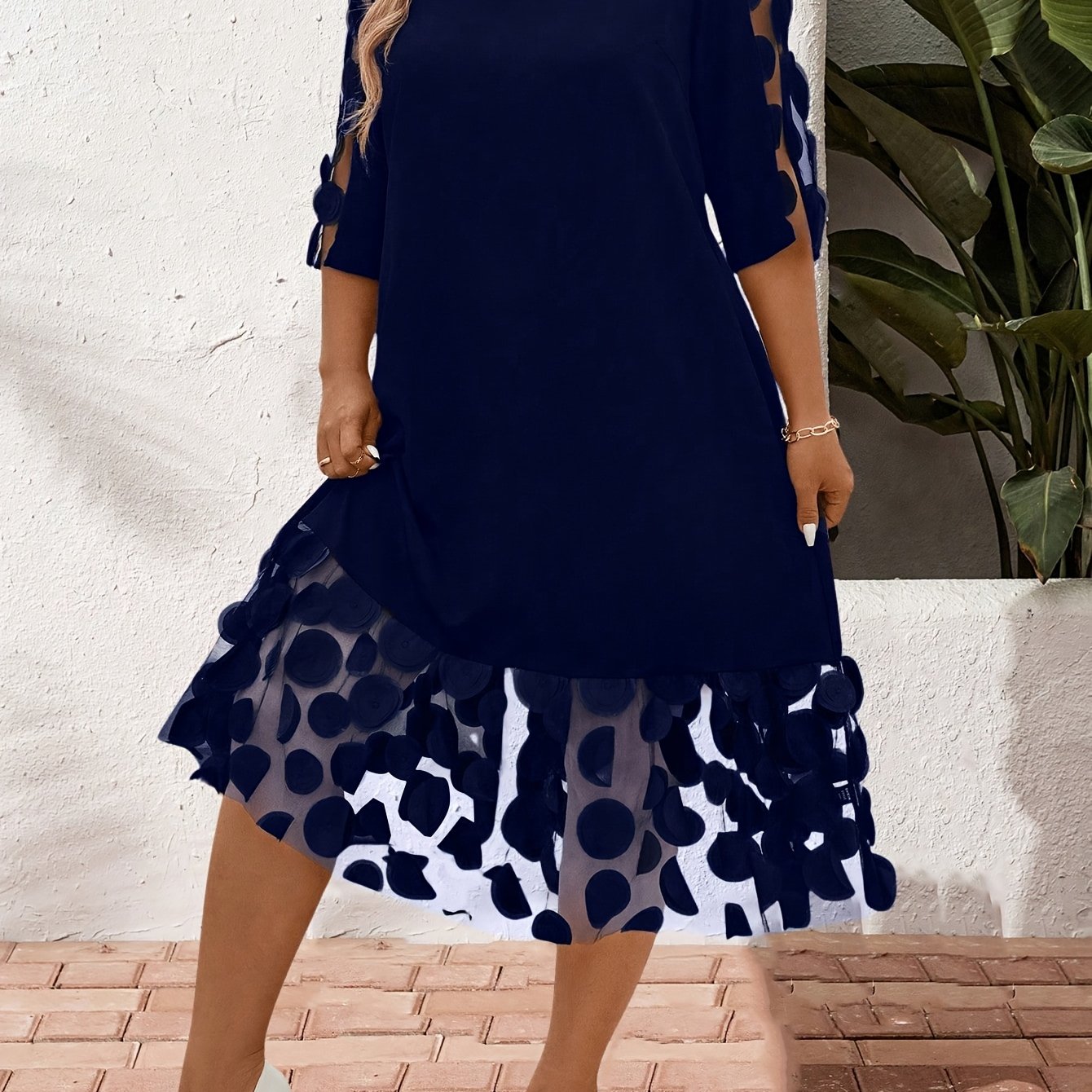 Robe élégante à manches courtes et col rond avec avec des pétales sur les bas et les bras.